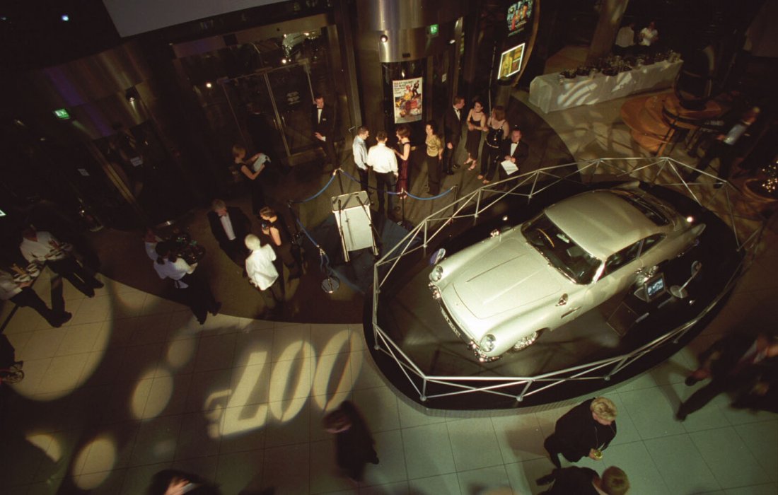 A birds-eye photograph of a silver car and the 007 logo