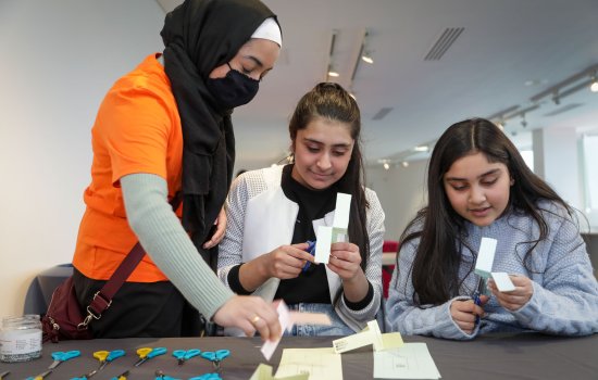 Girls taking part in museum activity with Explainer