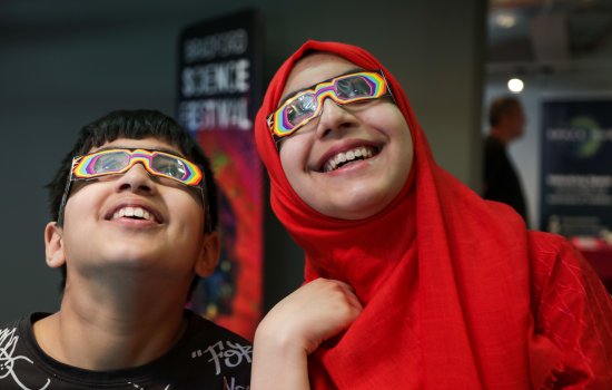 Two children wearing colourful glasses and smiling