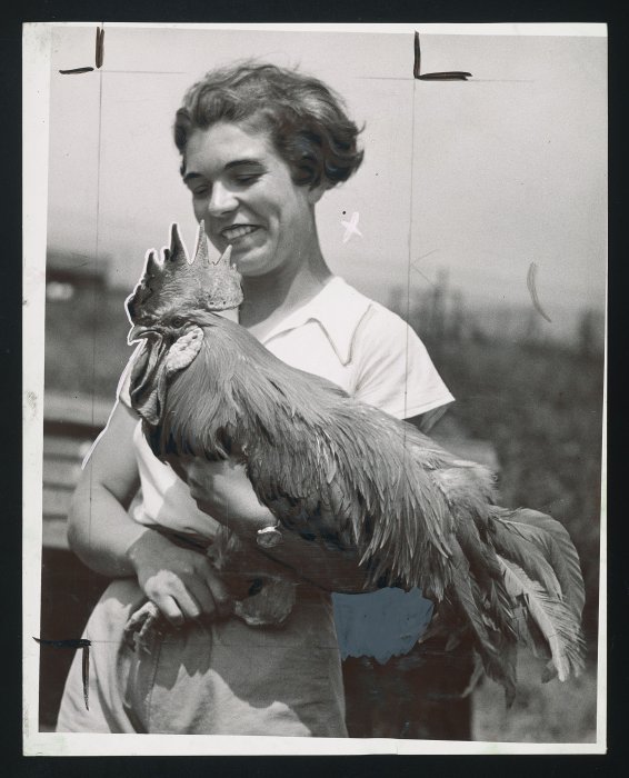 A woman holding a cockerel