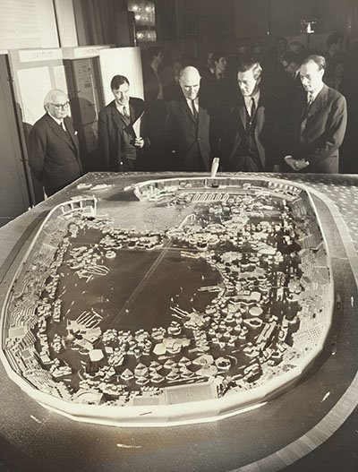 Group of men standing around a model of 'Sea City' stilted city
