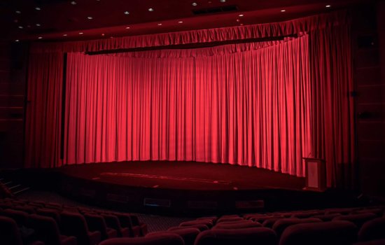 A red velvet curtain drawn across a cinema screen