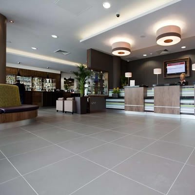 Hotel reception with tiled floor, seating and a large pot plant