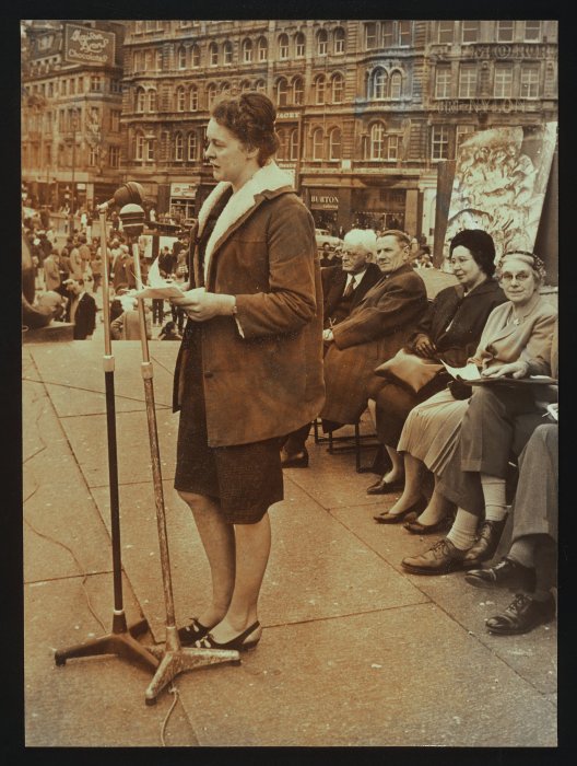 Woman addressing a crowd at a demonstration against factory farming