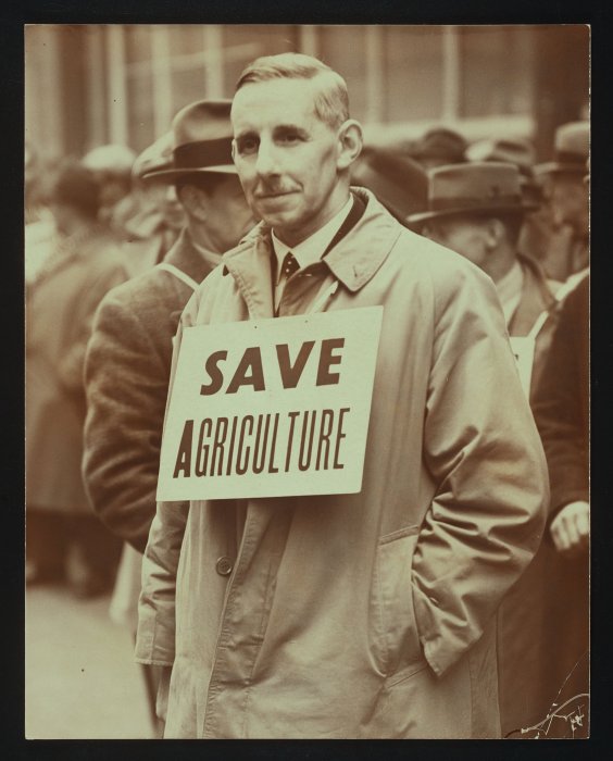 Man wearing placard reading 'Save Agriculture'