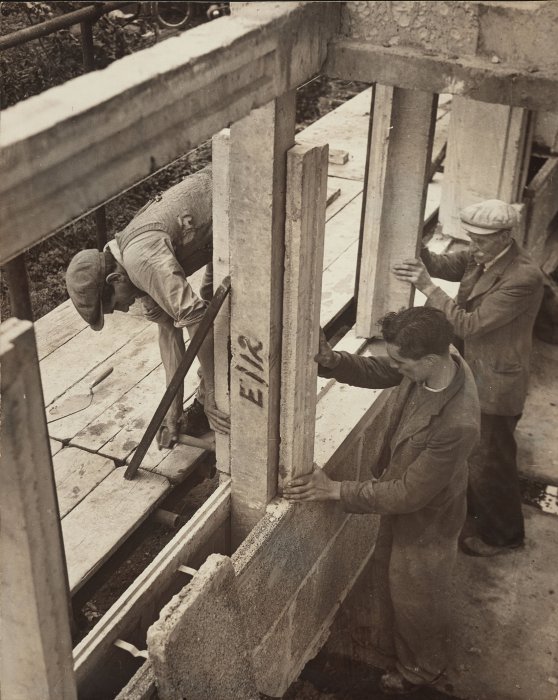 Builders working on concrete house