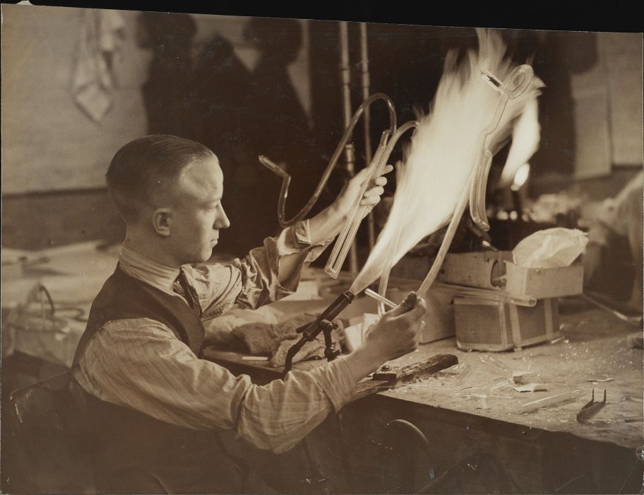 Man using flame to fashion a neon sign