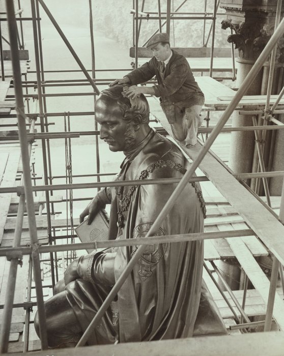 A steeplejack repairs damages to the Albert Memorial caused by bomb splinters