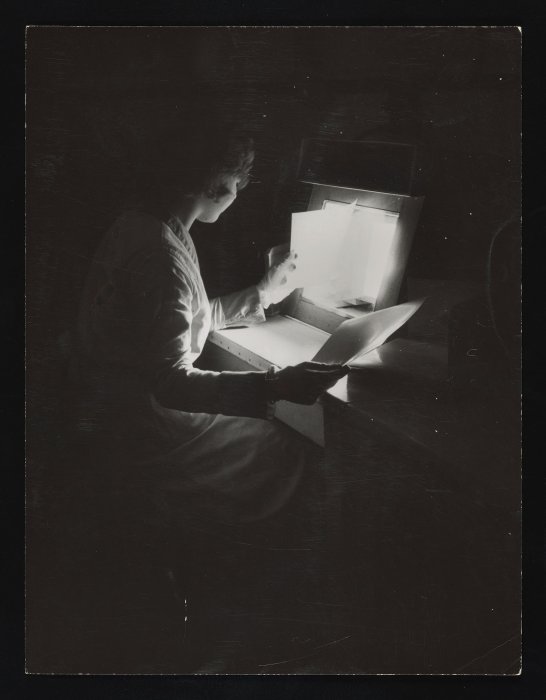 Factory worker checking quality of photographic film or paper