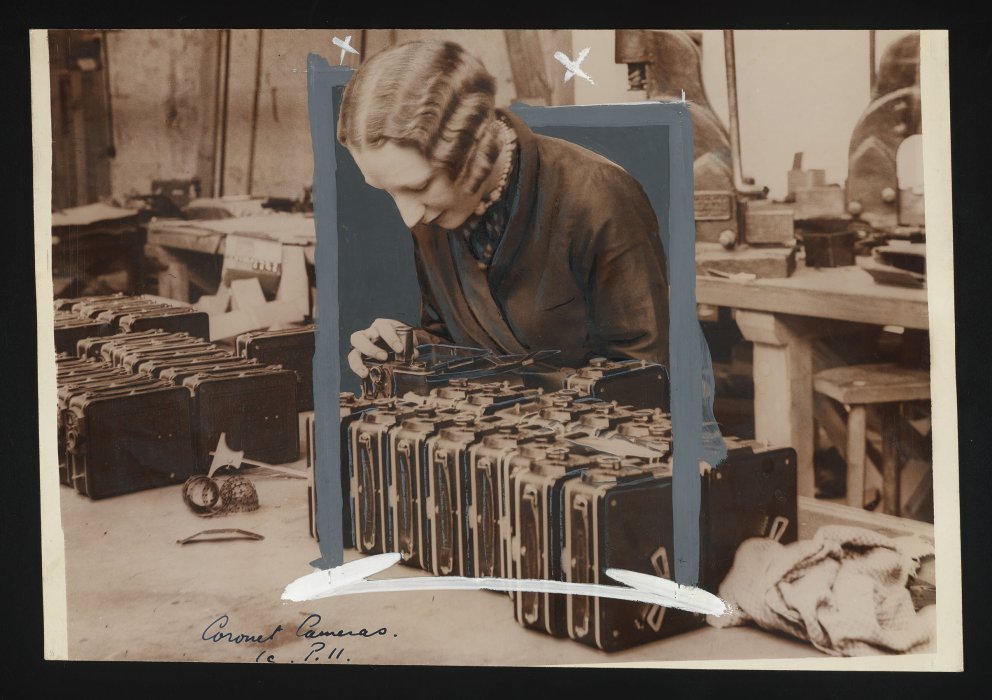 Factory worker inspecting a row of cine cameras