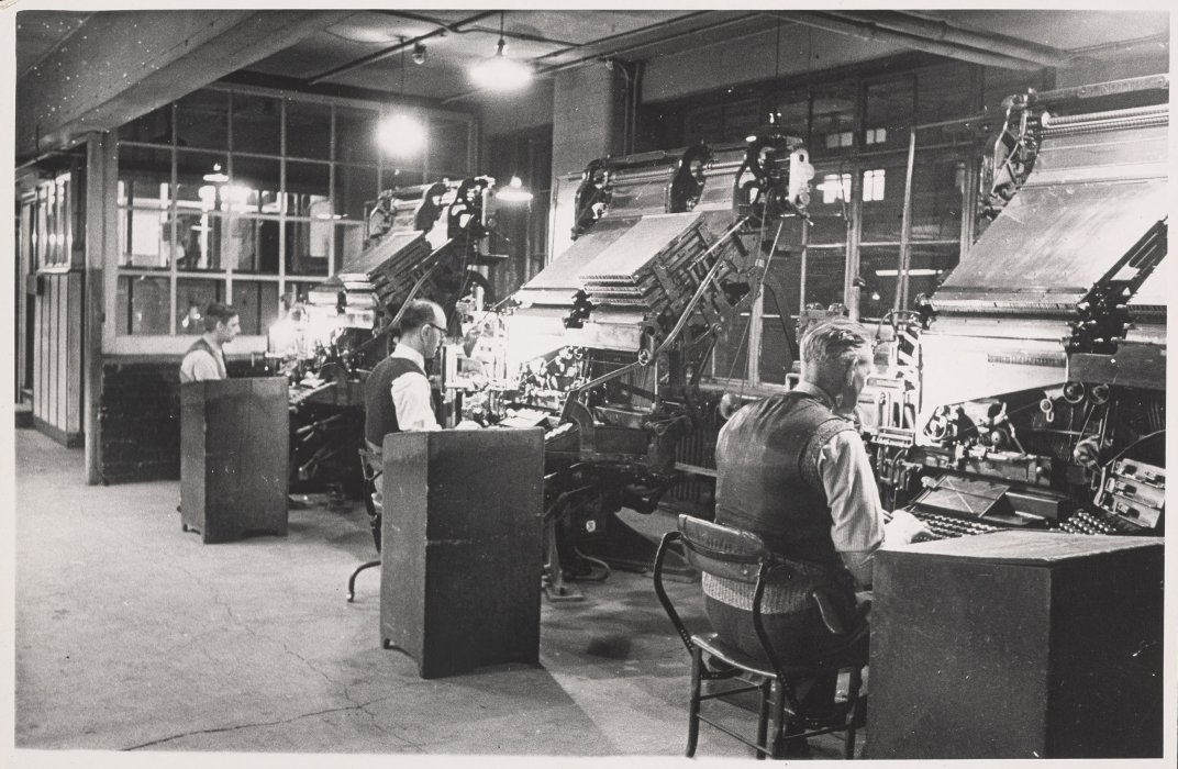 A row of lithographers at work on their machines in the Daily Herald office